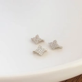 Detailed macro view of silver flower-shaped spacer charms with cubic zirconia micro-pave - Platinum Color (kp5881)