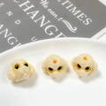 Close-up of three cream poodle beads with textured fur and top holes for DIY jewelry - Milky White (9#)