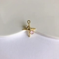 Macro detail of a gold starburst pendant with clear zircon and pink gemstone inlay - Gold + Light Pink