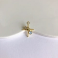 Detailed view of a gold cross pendant with light blue moonstone and zircon for DIY jewelry - Gold + Blue