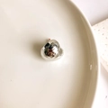 Detailed close-up of fluid silver C-shape earring on a minimalist ceramic display tray - Small Heart (Silver)