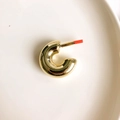 Close-up of chunky gold C-shaped hoop earrings on a white porcelain plate - Gold C-Shape (Large)