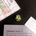 Detailed macro shot of a gold monster pendant with a green eye on a vintage background - Green Eye Gold Base