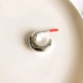 Detailed view of polished silver C-shaped chunky earrings on a white ceramic plate - Silver Crescent