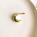 Top-down view of a chunky gold crescent earring on a clean white ceramic tray - Gold Small Crescent