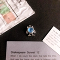 Detailed view of alloy monster pendant with blue cat eye stone on vintage background - Blue Eye Silver Base