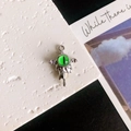 Detailansicht eines grünen Teufelsauge-Anhängers mit silbernen Flügeln und Schmelzeffekt - Grüne Augen