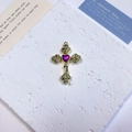 Detailed view of golden cross pendant with purple heart gem and rose relief motifs - Rose Heart Cross / Deep Pink + Gold
