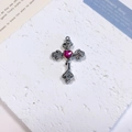 Macro detail of a silver cross pendant with rose relief and a red heart gemstone center - Rose Heart Cross / Deep Pink + White K