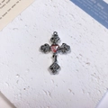 Detailed macro view of a silver alloy cross pendant with rose reliefs and a red heart gem - Rose Heart Cross / Orange + White K