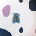Close-up of translucent blue-purple resin cartoon bear DIY charm with gold accents - Blue Marble Standing Dog