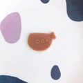 Close-up of cute fish-shaped pink acrylic DIY charm with golden glitter bubble details - Brown Fish