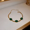 Golden snake chain bracelet featuring three oval emerald green gemstones with lobster clasp - Emerald Bracelet