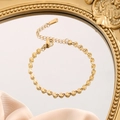 Gold titanium steel bracelet set with textured circular discs on a luxury mirror surface - Radiating Cut Bracelet (7731) / Gold