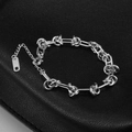 Makroaufnahme der 18K vergoldeten Knotenkette mit K18-Stempel auf dem Metallanhänger - Dornenkette Armband (7803) / Stahlfarben
