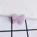 Détail macro du nœud en acrylique violet clair avec texture de perles de sucre scintillantes - Mauve Clair