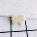 Gros plan d'un nœud en acrylique crème avec paillettes irisées pour bijoux DIY - Crème Clair Irisé