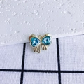 Detail view of a gold bow pendant with blue heart-shaped gems and metallic textures - Blue Heart Gold Base (5#)
