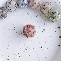 Nahaufnahme bunter Shamballa-Perlen mit Strass auf einem weißen gepunkteten Keramikteller - Rot Weiß Mix (4#)