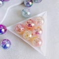 Dettaglio macro di perle acriliche da 16mm con superfici sfaccettate e tonalità colorate - Rosa Arancione Viola Blu (6#)