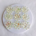 Close-up of 9 pieces of transparent aurora acrylic flower charms for DIY jewelry making - 33x6mm / Yellow Medium