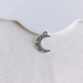 Macro shot of silver crescent moon pendant with rhinestones on a white textured background - Silver Rhinestone Moon (20#)