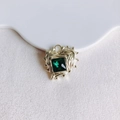 Detail of a heart-shaped gold pendant with an irregular wave texture and green zircon - Gold Green Gemstone (4#)