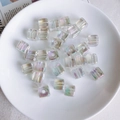 Nahaufnahme von 12mm Aurora Acrylperlen für DIY-Handwerk auf einem weißen Teller - Transparente Aurora-Farbe