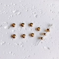 Vue macro de perles d'espacement remplies d'or 14K avec trou central pour bijoux DIY - 100 perles / 6mm