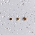 Macro shot of three 14K gold-filled snowflake spacer beads for DIY jewelry making - 4mm