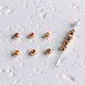 Macro detail of 14K gold filled textured beads with spiral engraving for DIY jewelry - 4mm