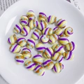 Macro-detail van ovale glazen kralen met kleurrijke spiraalstrepen en blauwe 3D-stippen - Paars Geel Oranje Spiraal Blauwe Stippen (3# Lampwork)