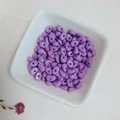 Close-up of purple glazed irregular teardrop beads for DIY jewelry making in a ceramic tray - Purple