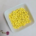 Macro shot of bright yellow oval spacer beads for handmade jewelry in a white tray - Bright Yellow