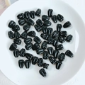 Macro shot of black teardrop-shaped acrylic beads with longitudinal textures in a white dish - Black Flower Bud Bead (02#)