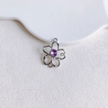 Gros plan détaillé d'un pendentif fleur argenté avec un strass violet au centre - Fleur Creuse Argentée Strass Violet (7#)