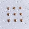 Macro shot of 9 gold flower-shaped spacer beads for DIY jewelry making and necklace crafts - Style 6 (6#)