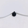 Detailed view of a matte black round alloy pendant with radial star engraving on a white tray - Black Bun Style (2#)