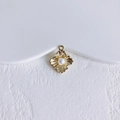 Detailopname van vintage gouden bloemhanger met parel op minimalistische witte steen - Goud Kunstparel Bloem Stijl (3#)