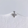 Gros plan d'un pendentif étoile argenté avec texture perlée sur un socle en pierre blanche - Style Étoile Argenté (6#)