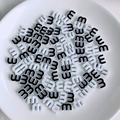 Macro view of candy-colored alphabet beads with letter M for DIY jewelry making - White and Black Style (6)