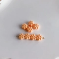 Dettaglio di perline a fiori in acrilico arancio pesca per gioielli su ceramica bianca - Arancio Pesca