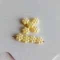 Dettaglio del fermaglio per capelli a fiori in acrilico giallo con finitura perlata - Giallo