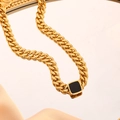Goldene Gliederkette mit schwarzem quadratischem Emaille-Anhänger auf Champagner-Satin - Gold Halskette