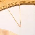 Golden heart pendant necklace with pink birthstone on silk background - October (Pink)