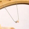 Minimalist stainless steel necklace with pearl and silver bead pendant on a mirrored surface - Pearl Necklace / Steel