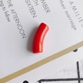 Macro detail of glossy red curved tube bead with holes for DIY jewelry making - 10 Pieces Pack / Red