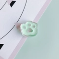 Detail of mint green resin cat paw bead showing glossy texture and transparent edge - Green