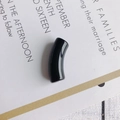 Close-up of a glossy black curved resin tube bead for DIY necklace and bracelet crafting - 10 Pieces Pack / Black
