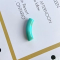 Macro shot of turquoise translucent curved tube bead with marble texture for jewelry - Cyan Green Texture